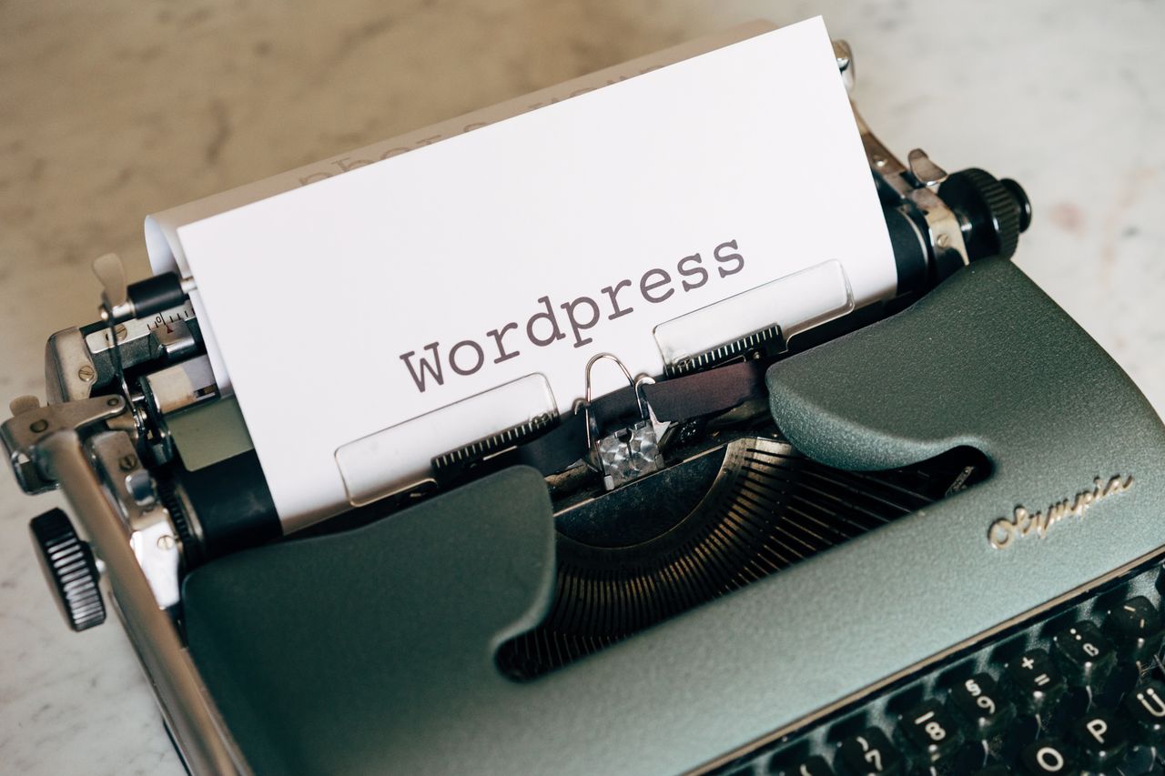 Krupan plan vintage pisaćeg stroja s papirom na kojem piše WordPress.